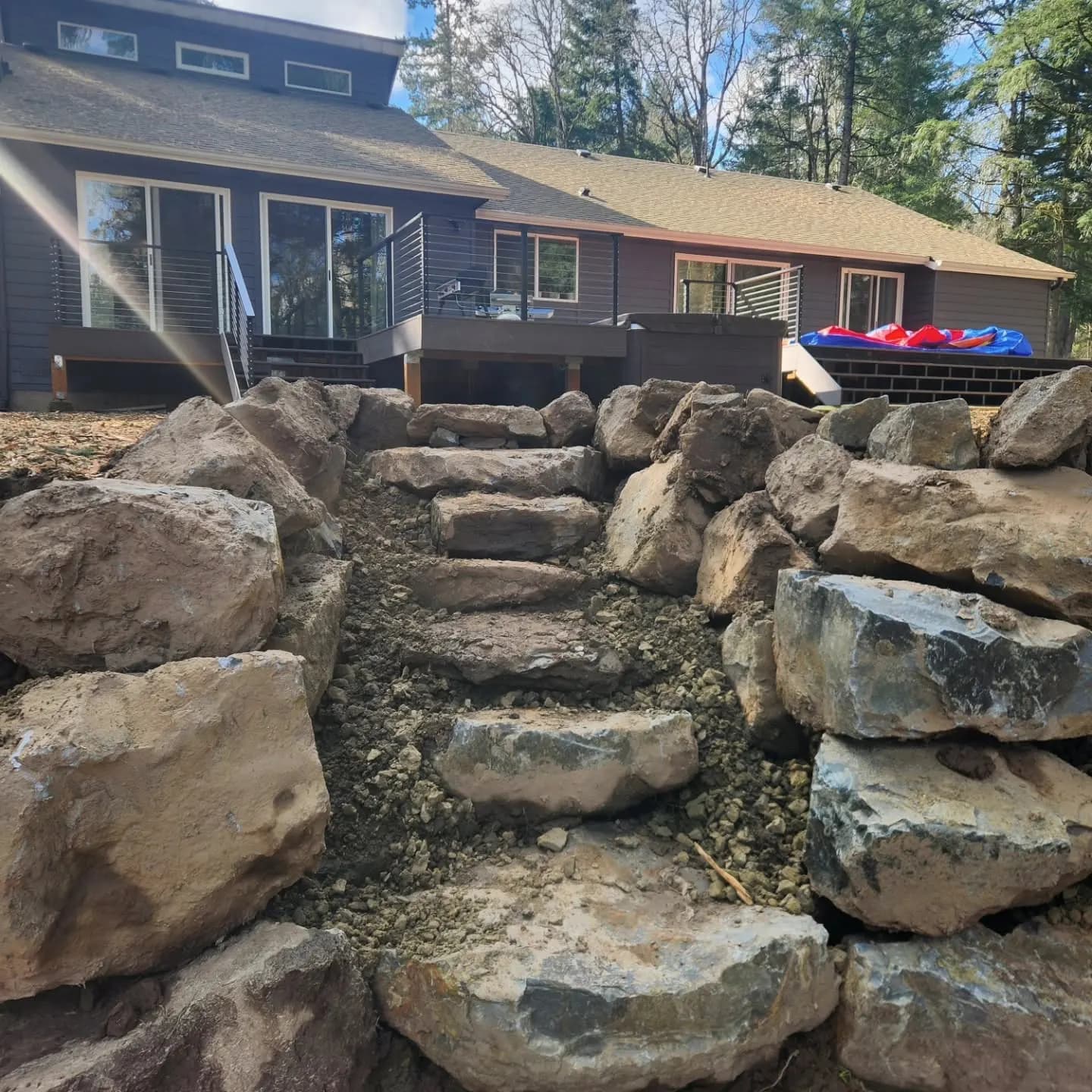 Boulder steps set into a slope behind a house